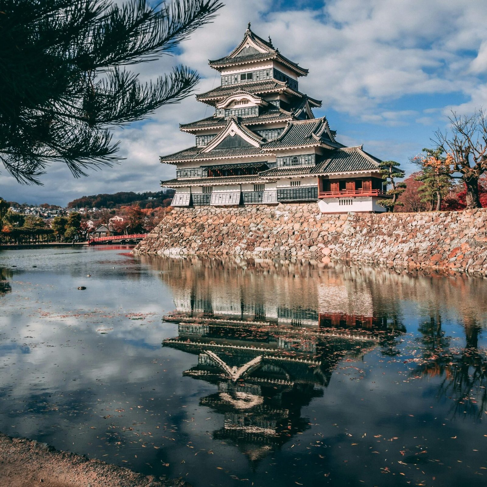 Reflection of Matsumoto Castle in Japan during autumn, surrounded by a serene lake.