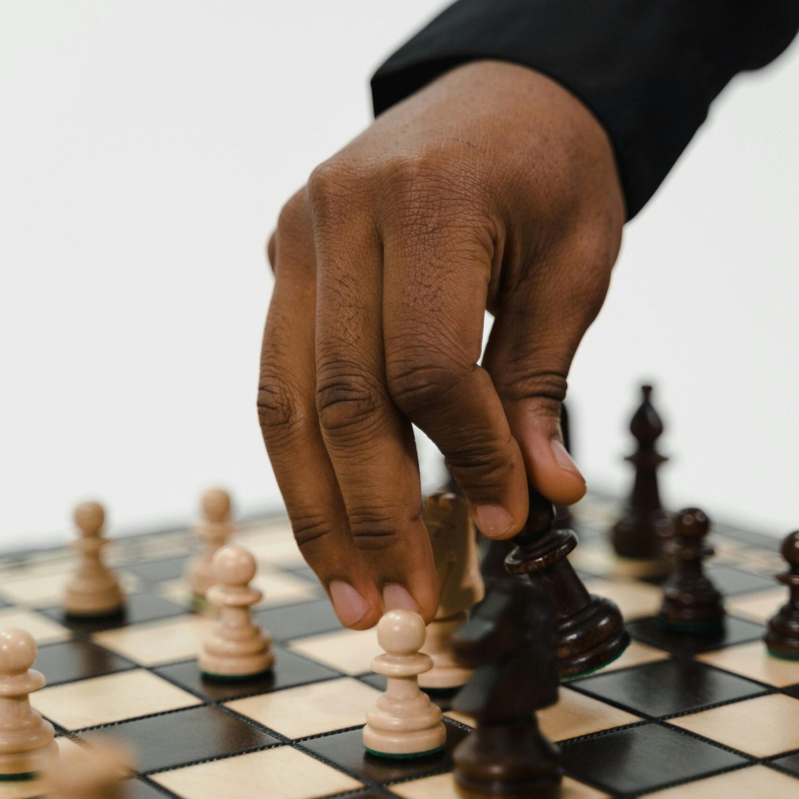 Close-up of a hand making a chess move, highlighting strategic gameplay and decision-making.