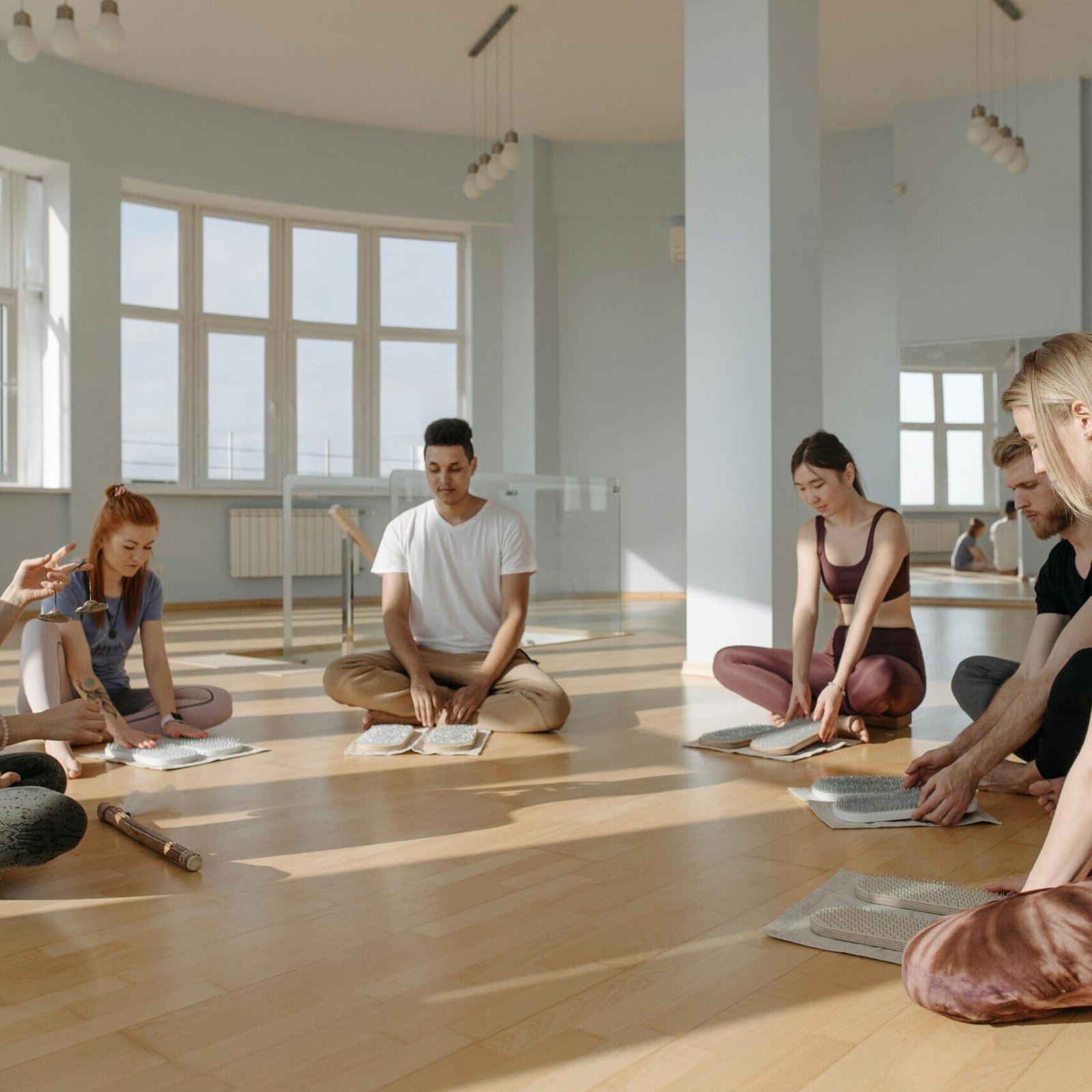 A diverse group of people meditating together indoors, creating a serene and peaceful environment.